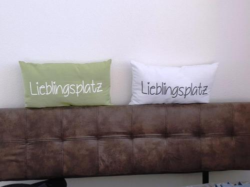 two pillows sitting on top of a brown couch at Casa Vierthaler in Scheffau am Wilden Kaiser