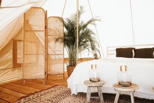 a bedroom with a bed and two tables at Dreamsea Mediterranean Camp in Benitachell