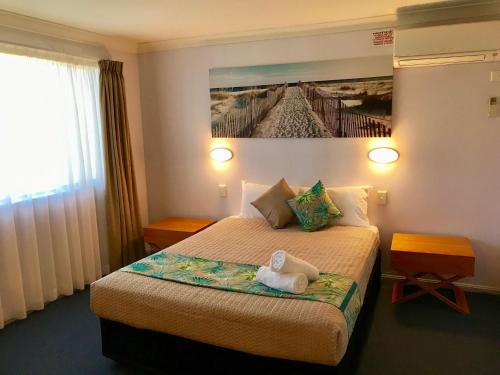 a hotel room with a bed with a stuffed animal on it at Cleveland Bay Air Motel in Cleveland