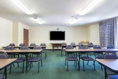 a room with tables and chairs and a flat screen tv at Sleep Inn & Suites Bay View Acme - Traverse City in Traverse City