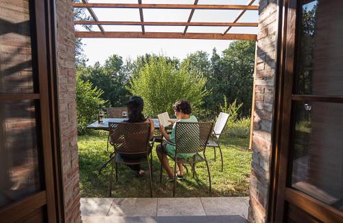 two women sitting at a table in a yard at Falesta in Casole dʼElsa