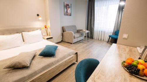 a hotel room with a bed and a table with a bowl of fruit at Time Hotel in Kyiv