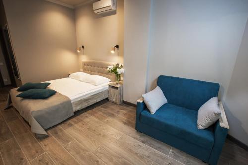 a bedroom with a bed and a blue couch at Time Hotel in Kyiv