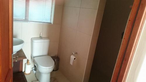 a small bathroom with a toilet and a sink at 4 On Braemar in Nottingham Road