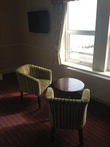 a room with two chairs and a table and a window at Best Western Hotel Hatfield in Lowestoft