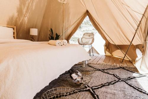 a bedroom with a tent with a bed and a chair at Dreamsea Mediterranean Camp in Benitachell