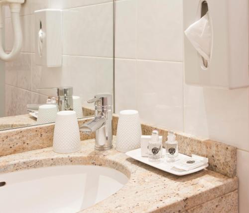 فندق ديس دوكس دأنجو في باريس: منضدة الحمام مع الحوض والمرآة