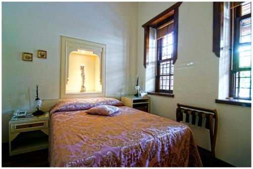 a bedroom with a bed and a table and windows at Minyon Hotel in Antalya