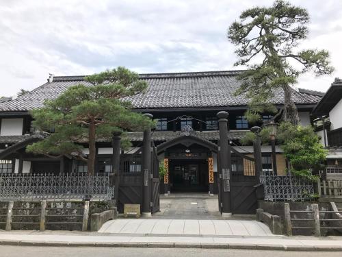 an entrance to a building with trees in front at BEYOND HOTEL Takayama 2nd in Takayama