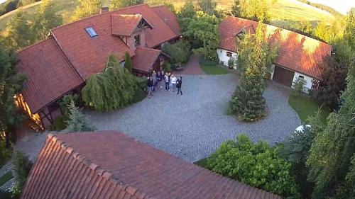 a group of people standing in front of a house at Dworek Szyszki - Kaszuby in Liniewko