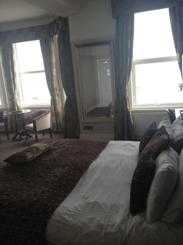 a bedroom with a large bed and two windows at Best Western Hotel Hatfield in Lowestoft