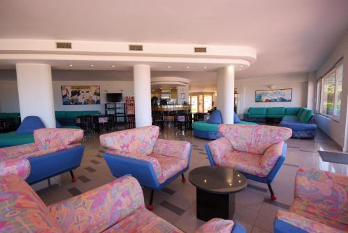 a waiting room with blue and pink chairs and tables at Hotel Residence Isola Verde in Marciana Marina