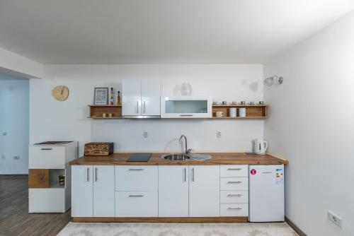 a kitchen with white cabinets and a sink at Premium Inn in Gevgelija