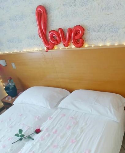a bed with a heart shaped love sign above it at Hotel Alessandra in Garda