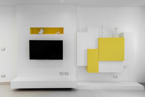 a living room with a tv and some yellow objects at Benviar Tonson Residence in Bangkok