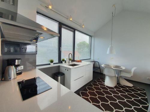 Una cocina con un fregadero y una mesa dentro. en Boulevard - 365PAM, en Ustronie Morskie