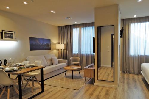 a living room with a couch and a table at Bilbao City Center by abba Suites in Bilbao