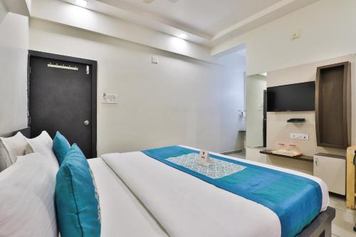 a bedroom with a large bed and a television at The Gir Harmony Hotel in Sasan Gir