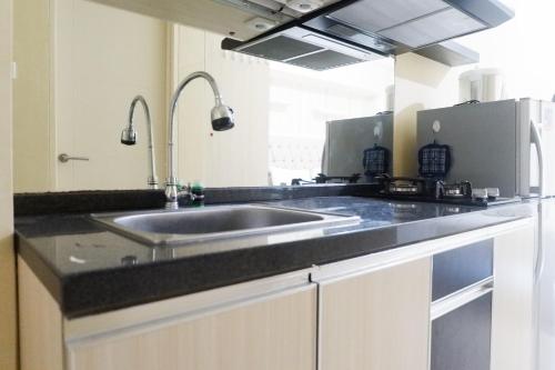 a kitchen with a sink and a counter top at Clean Studio Apartment Connected to Mall at Orchard Supermall Mansion By Travelio in Surabaya