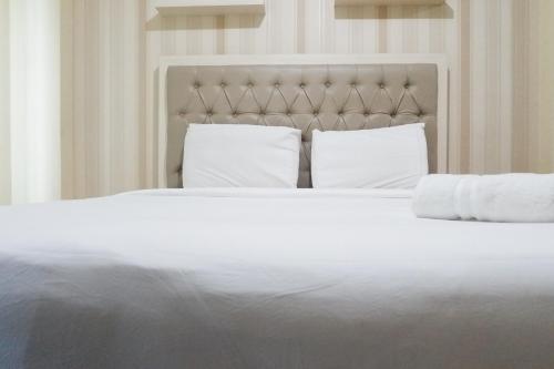 a large white bed with two pillows on it at Clean Studio Apartment Connected to Mall at Orchard Supermall Mansion By Travelio in Surabaya