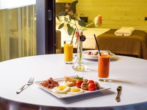 Een bord met ontbijtproducten op tafel, met sap erbij. bij Chalet Greenwood in Beloe Ozero