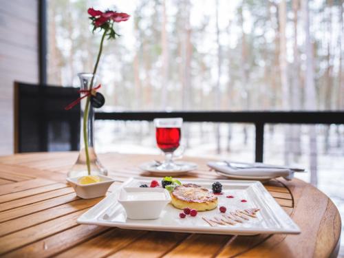 een bord eten en een glas wijn op tafel bij Chalet Greenwood in Beloe Ozero