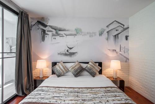 a bedroom with a large bed with two lamps at Benviar Tonson Residence in Bangkok