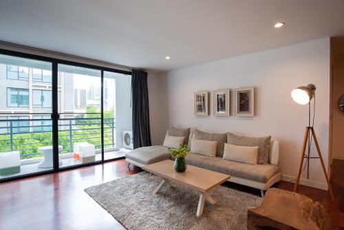 a living room with a couch and a table at Benviar Tonson Residence in Bangkok