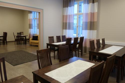 a dining room with tables and chairs and windows at LentoHotelli in Kauhava