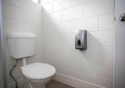 un bagno con servizi igienici e un dispenser di sapone sul muro di Banjo Paterson Motor Inn a Townsville