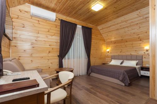 a bedroom with a bed in a wooden cabin at Kompleks Otdykha Elki-Palki in Odesa