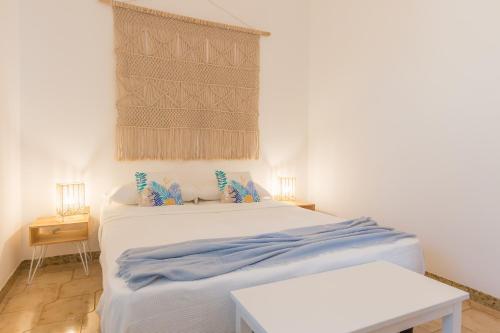 ein Schlafzimmer mit einem weißen Bett mit blauer Bettwäsche in der Unterkunft Villa Del Pero in Torre Lapillo