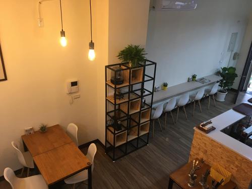 a dining room with tables and chairs and a shelf with plants at 360 Coffee Homestay in Nantou City