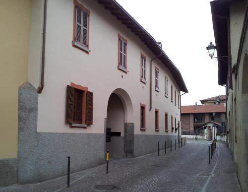 a white building with an archway on a street at Borromeo Rooms Bed & Living in Vimercate