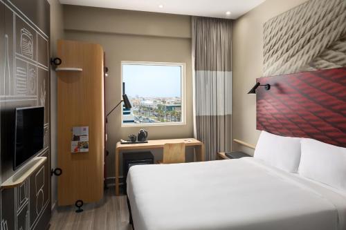 a hotel room with a bed and a window at Ibis Jeddah Malik Road in Jeddah