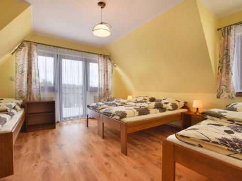 a bedroom with two beds and a window at U Pawlikowskich in Poronin