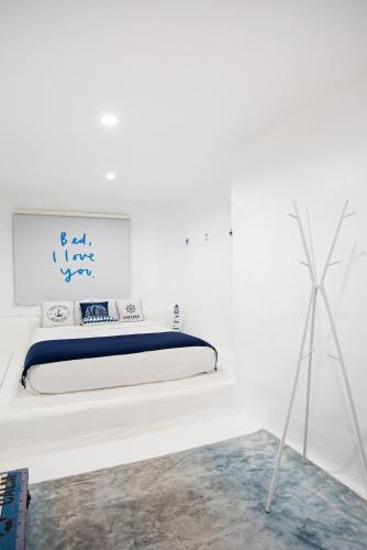 a white room with a bed on a white wall at Benviar Tonson Residence in Bangkok