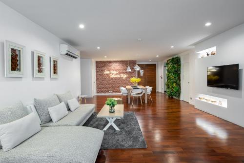 a living room with a couch and a table at Benviar Tonson Residence in Bangkok