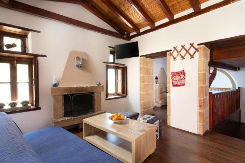 Ypatia Cozy Castle Suite Apartment with Loft في مونيمفاسيا: غرفة معيشة مع أريكة ومدفأة
