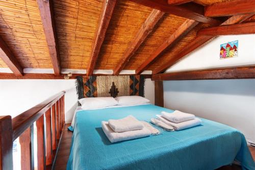 a bedroom with a blue bed with towels on it at Ypatia Cozy Castle Suite Apartment with Loft in Monemvasia