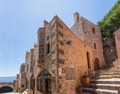 an old stone building with stairs in front of it at Ypatia Cozy Castle Suite Apartment with Loft in Monemvasia