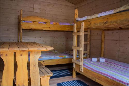 a cabin with two bunk beds and a table at Bike Camping in Przewóz