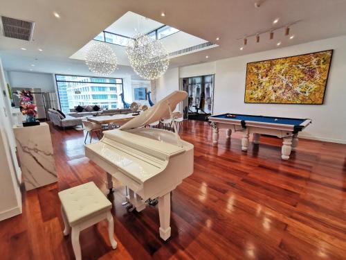 sala de estar con 2 pianos y mesa de billar en Benviar Tonson Residence, en Bangkok