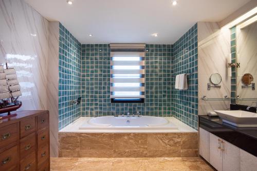 a bathroom with a bath tub and a sink at Benviar Tonson Residence in Bangkok