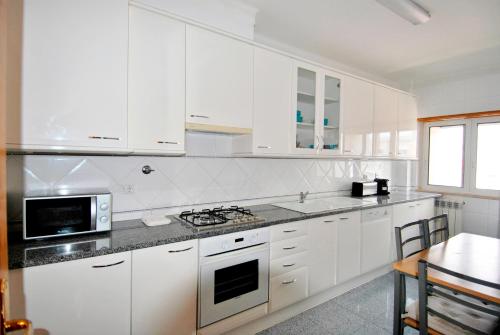 a kitchen with white cabinets and a stove top oven at Down Town Apartment - EXPO27 in Lisbon
