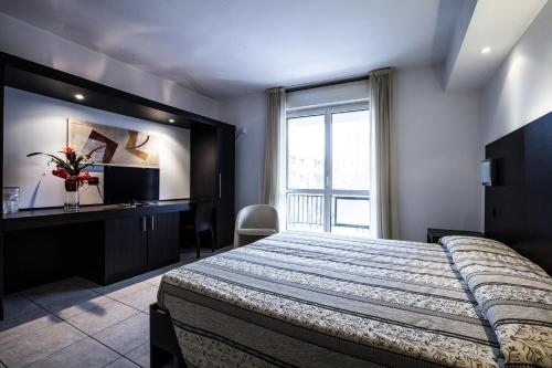 a bedroom with a large bed and a window at Hotel Davide in Rivoli