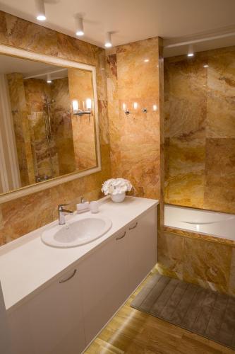 a bathroom with a sink and a mirror and a tub at Antakalnis 5 stars apartment in Vilnius