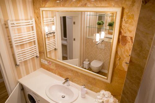 a bathroom with a sink and a mirror at Antakalnis 5 stars apartment in Vilnius