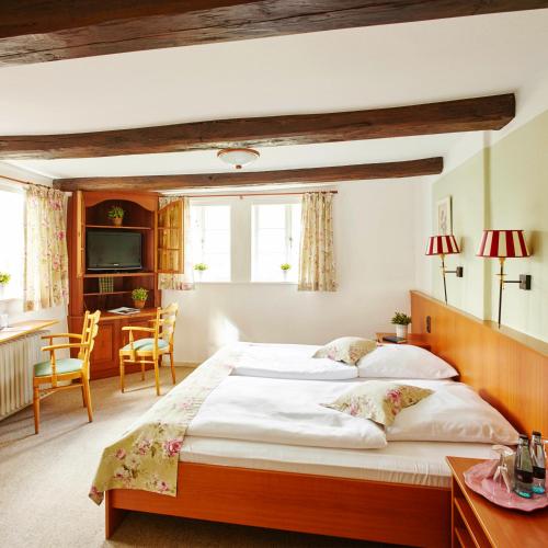 a bedroom with a large bed and a desk at Landhaus Haverbeckhof in Niederhaverbeck
