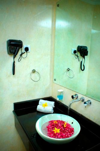 a bathroom with a sink with flowers in it at Zurich Hotel Balikpapan in Balikpapan
